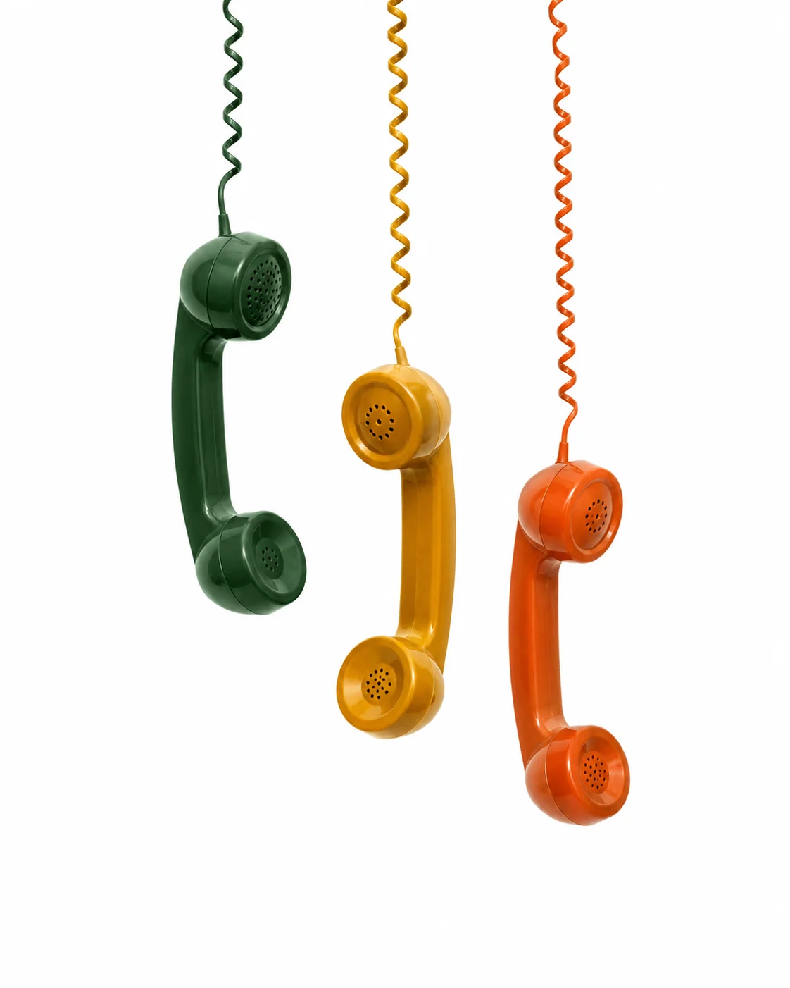 Drei Retro-Telefonhörer in Dunkelgrün, Gelb und Orange hängen an ihren Spiralkabeln