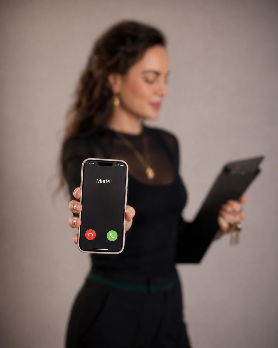 Roxane Freytag hält ein Smartphone, auf dem Display steht Mieter
