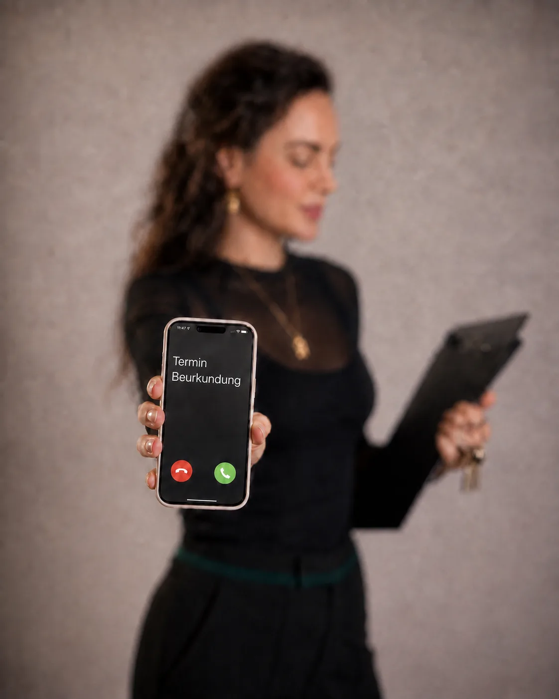 Roxane Freytag hält ein Smartphone, auf dem Display steht Termin Beurkundung