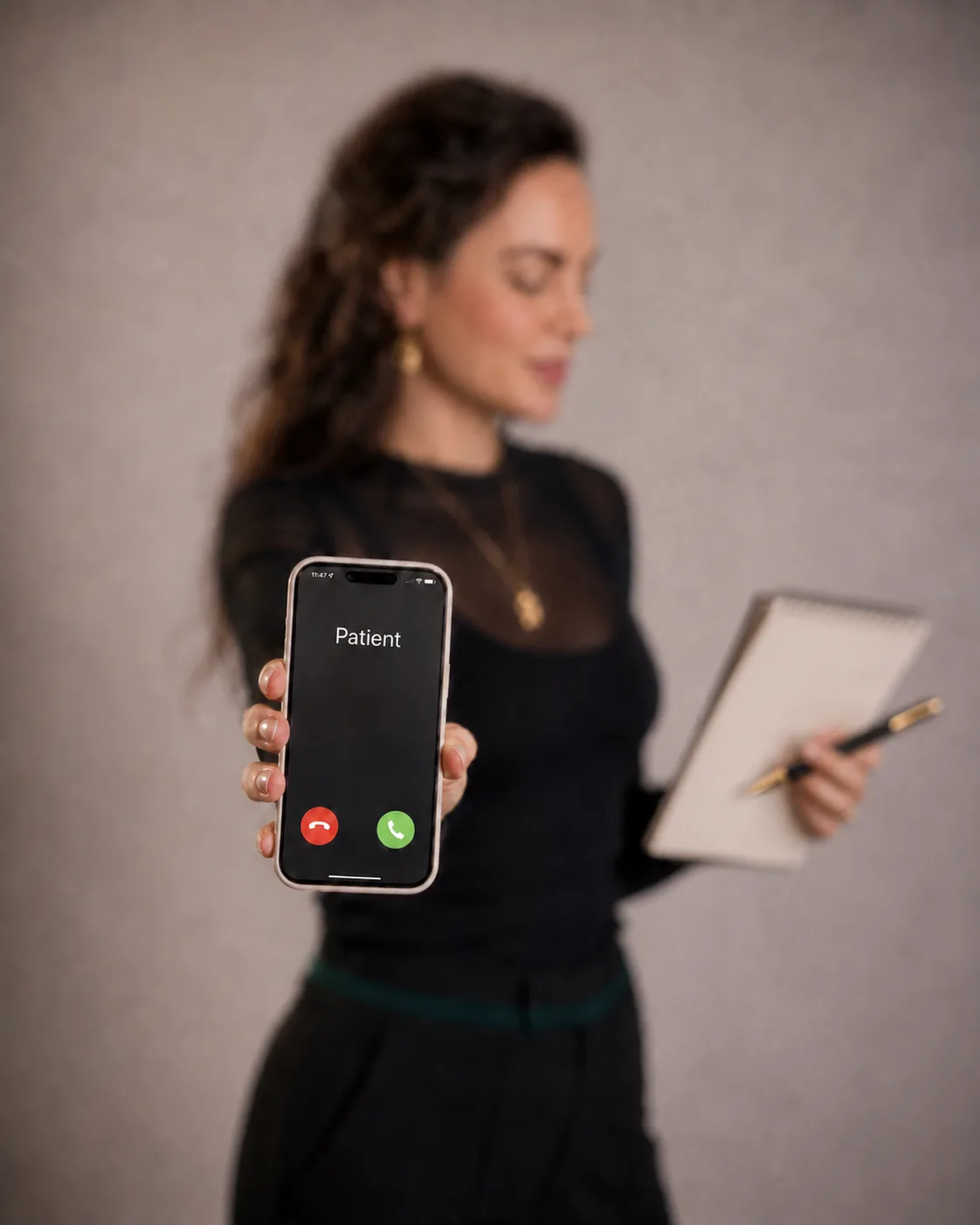 Roxane Freytag hält ein Smartphone, auf dem Display steht Patient