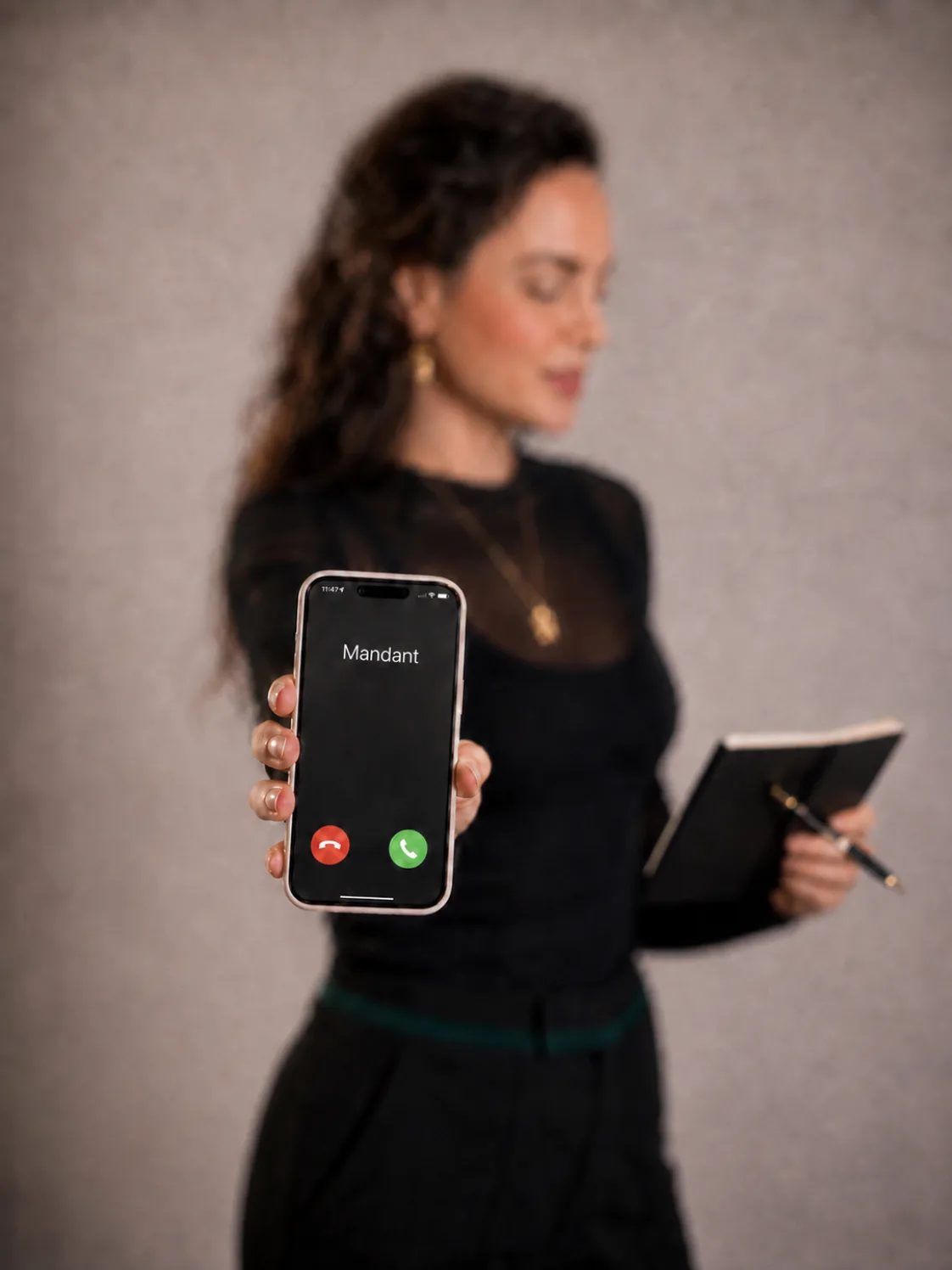 Roxane Freytag hält ein Smartphone, auf dem Display steht Mandant